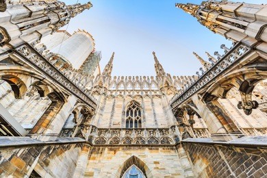 wide angle worm's eye view of gothic architecture and art on the roof of milan cathedral (duomo di milano), italy