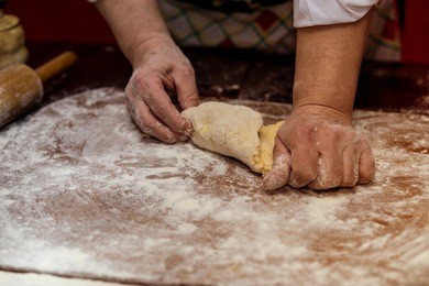 female hands making dough for pizza. making bread. cooking process concept