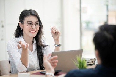smiling and beautiful female ceo wearing glasses talking with company subordinates, discussing business strategies. leadership concept