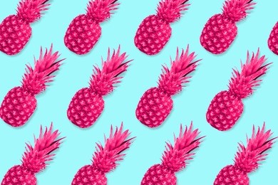 colorful fruit pattern, neon pink pineapples on a pastel blue background. top view.