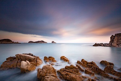 long exposure sea landscape photo at beautiful bay with rocks on a front