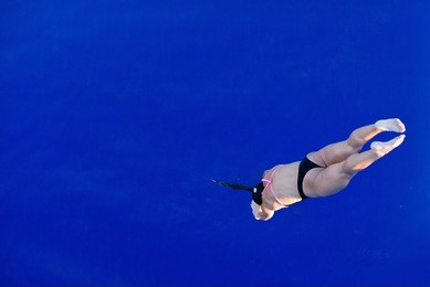 female diver jump into the pool