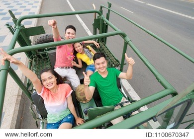 group of happy young people traveling by jeep