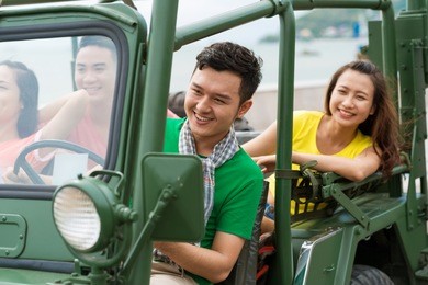 happy friends having fun while traveling by car