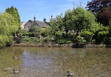 houses beside the river windrush in bourton - on - the - water.