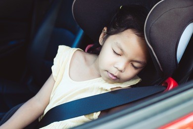 cute asian little child girl sitting in the car seat and sleeping in the car