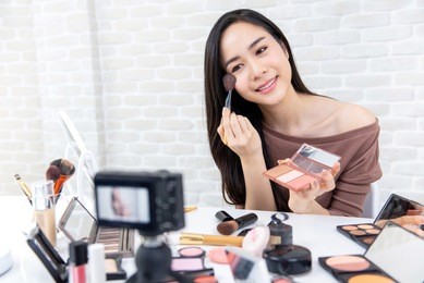 young beautiful asian woman professional beauty vlogger or blogger recording make up tutorial to share on social media