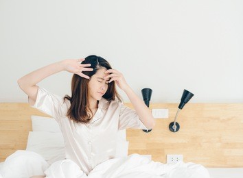 portrait of asian woman stretching in bed after wake up. woman lifestyle after wake up.