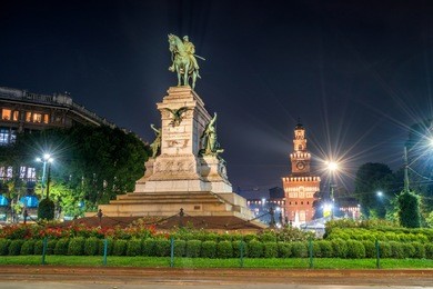 giuseppe garibaldi monument in milan, italy and sforza castle (castello sforzesco) at night. they is the famous travel destination for tourist visiting milan, italy.
