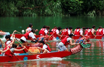 scene of a competitive boat racing in the traditional dragon boat festival in taipei, taiwan, with view of athletes pulling vigorously on their oars and competing strenuously in colorful dragon boats