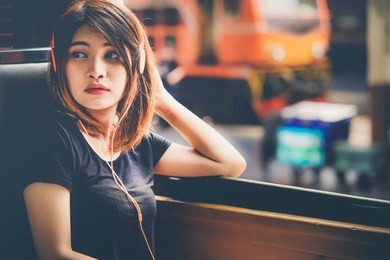 traveler alone on the train, beautiful young asian teenage hipster girl listening to earphone traveling in a train,travel lifestyle and seasonal vacation concept.