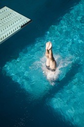 high angle view of a male diver's legs diving into the pool