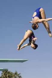 full length of two female diving from springboard