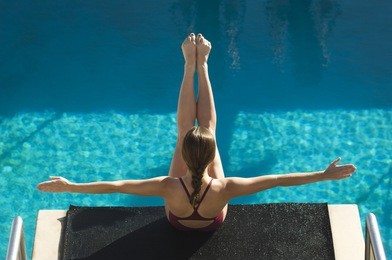 high angle view of a female diver on diving board with arms out