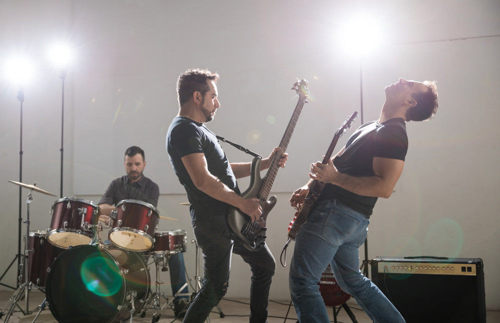 rock and roll band guitarists performing together on stage at a rock concert