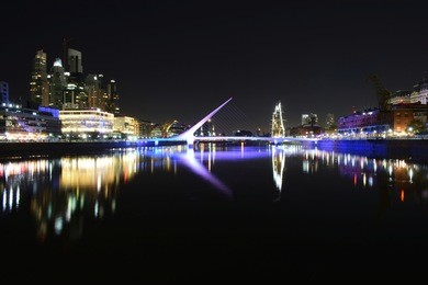 night photo of skyline of puerto madero with woman´s bridge (puente de la mujer), buenos aires, argentina. long exposure
