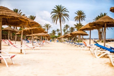 sunbeds with parasols on snow-white sand on beach