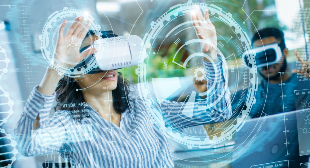 female virtual reality engineer/ developer wearing virtual reality headset creates content with her colleagues. bright young people work with holograms in augmented & mixed reality project.