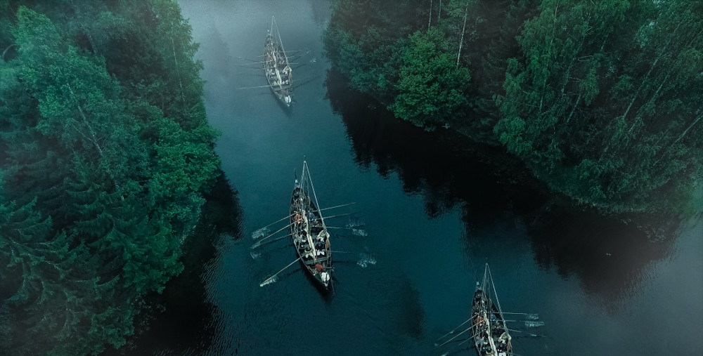 aerial shot of a sailing viking row ships on river. medieval reenactment.