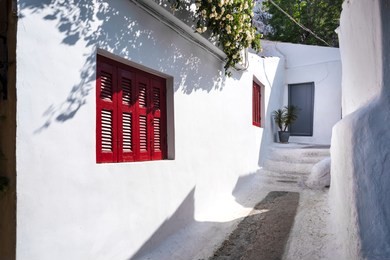 greece, athens: traditional picturesque scenic houses with red window frames of anafiotika district below famous acropolis in the city center of the greek capital - concept travel history tradition