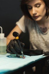 special paint for doing tattooing. preparation of professional tattoo artist to work, taking ink with special machine, closeup