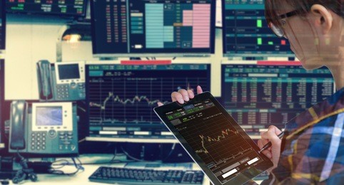 double exposure of business woman holding tablet for stock market quotes and chart in monitor computer room with business office equipments .business and money trading concept.