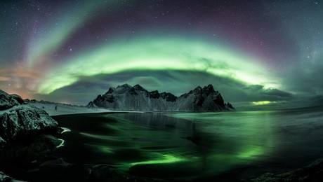 panoramic aurora borealis (northern lights) above vestrahorn mountain range, iceland