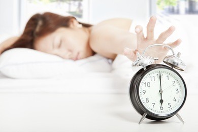 woman turning off the alarm clock