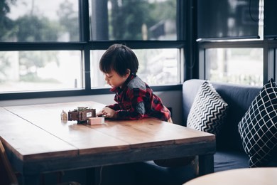 asian kid playing toys on the table at home funny, learning and happinese. look vintage style
