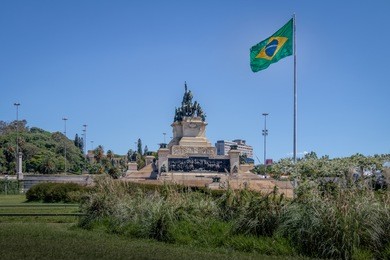 monument to the independence of brazil (monumento a independencia do brasil) at  independence park (parque da independencia) with brazilian flag in ipiranga  - sao paulo, brazil