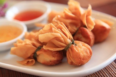 close up of crab rangoon with sauce