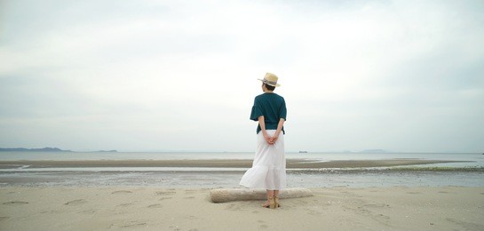 asian woman standing at the beach