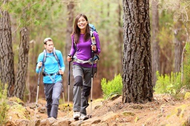 hikers in forest. couple hiking in fall forest. asian woman hiker in front smiling happy. photo from aguamansa, orotava, tenerife, canary islands, spain.