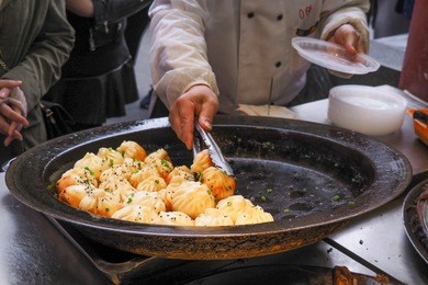 big frying pan with sheng jian bao-traditional chinese pan fried dumplings with minced pork shrimp and vegetables in shanghai china, cantonese food,pan-fried
