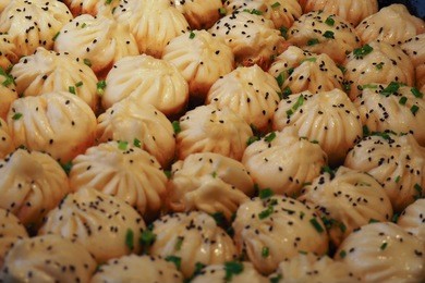 big frying pan with sheng jian bao-traditional chinese pan fried dumplings with minced pork shrimp and vegetables in shanghai china, cantonese food,pan-fried
