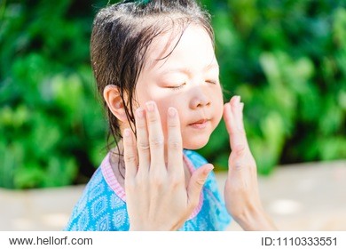 mother applying sunscreen lotion on her daughter.sunscreen protection uv sun light on the beach.