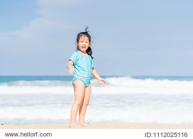 little asian girl walking and stand on sea sand on the beach.vacation and relax concept.playful active kid on beach in summer vacation.
