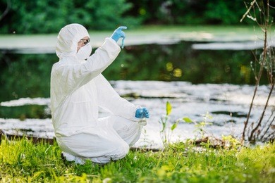 biologist wearing protective uniforms working on water analysis. ecology and environmental pollution concept.