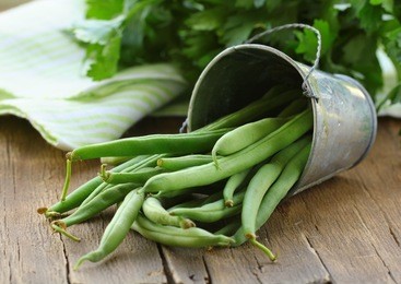 pods of green peas on a wooden table, rustic style