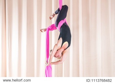 asian woman training in a fitness room with fly yoga elements