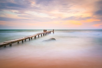 long exposure shot of the ocean and a pier in a sunset on phu quoc island in vietnam.