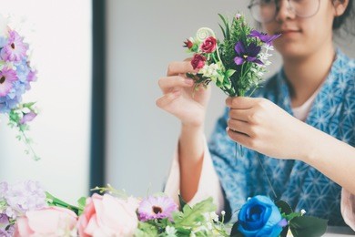 florist's creative work requires senses of style beauty and proportion. woman making beautiful flower arrangement.