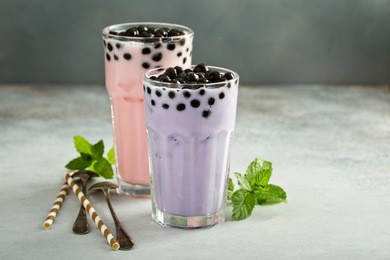 taro and strawberry milk bubble tea with ice in tall glasses