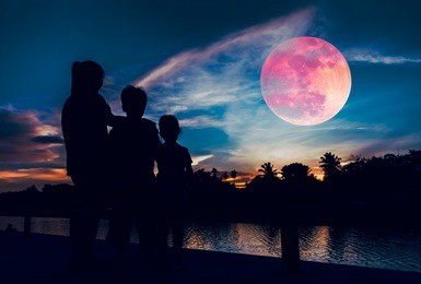 silhouette of mother and children looking at red super moon or blood moon on colorful sky with cloud. serenity nature background. happy family spending time together. the moon taken with my camera.
