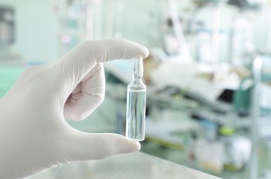 ampoule in the hand of the medical workers against hospital ward. photo