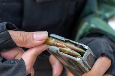 loading ammunition in gun magazine.