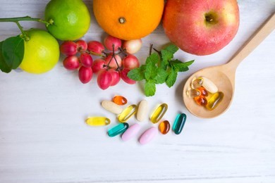 multivitamin supplements from fruit on white wooden background.top view.