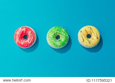 creative arrangement of colorful donuts on pastel blue background. minimal food concept. flat lay.
