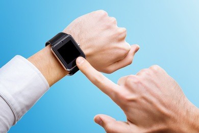 businessman is pointing at smart hand with smart watch isolated at blue background.