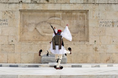 soldiers of the presidential guard marching in front of the monument of the unknown soldier in athens, greece.